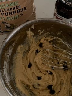 a mixing bowl filled with batter next to a bag of flour