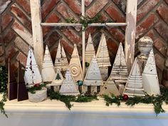 an old window frame decorated with christmas trees and other decorations on display in front of a brick wall