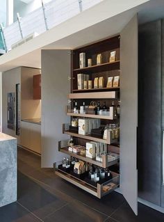 an open kitchen with lots of counter space and shelves on the wall, along with various items