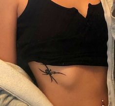 a woman with a spider tattoo on her stomach