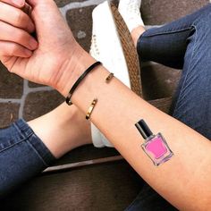 a woman's arm with a pink perfume bottle tattoo on it