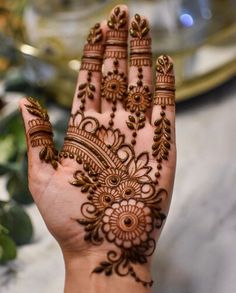 a woman's hand with henna tattoos on it