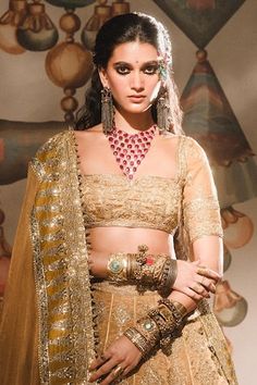 a woman in a bridal outfit with jewelry on her neck and hands behind her back