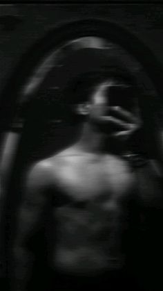 black and white photograph of a man's shirtless torso in front of a mirror