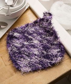 a close up of a purple rug on a wooden table next to plates and utensils