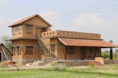 a wooden house sitting on top of a lush green field