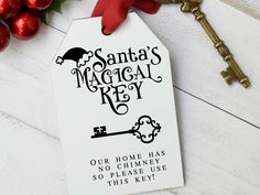 a white tag with the words santa's magic key on it next to christmas decorations