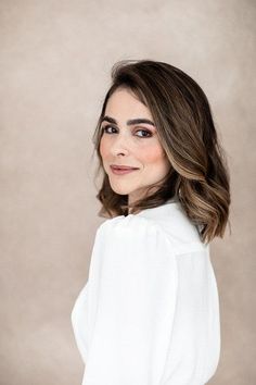 a woman with shoulder length hair wearing a white blouse