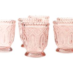 four pink glass vases sitting next to each other