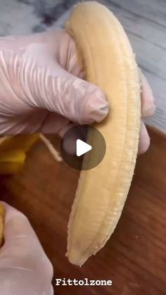 a person wearing gloves is peeling a banana