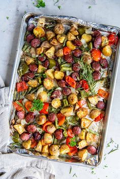 a pan filled with potatoes, carrots and other veggies on top of a table