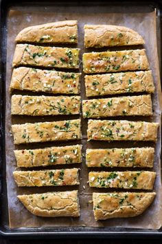 sliced bread with herbs on top in a baking pan ready to go into the oven