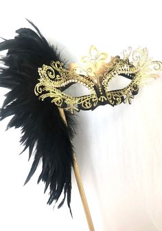 Black Gold feather masquerade mask women This Beautiful, bold and regal Filigree design masquerade mask is painted and embellished with large Feather design, fine shimmers and diamond jewels. S H I P P I N G - Processed same day or within 24 hours. 1-2 day guaranteed delivery, add item to cart, click shipping tab for rates. Pls leave a check out note with your need date & contact number Msg for delivery time frames (Include your state/country) S I Z E Adult size Masks. Detailed dimensions av Masquerade Mask Ideas Diy, Black And Gold Masquerade Mask, Blue Masquerade Mask, Pink Masquerade Mask, Mask Masquerade Ball, Gold Masquerade Mask, Masquerade Party Decorations, Mask Venetian