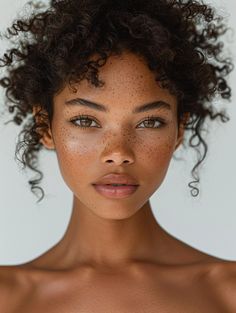 a woman with freckles on her face is looking at the camera while wearing a bra