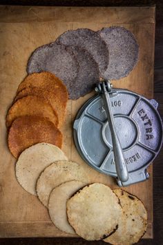 an assortment of food on a cutting board including pita bread and tortilla chips