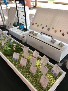 the table is filled with jewelry and bracelets for sale at an outdoor market stall