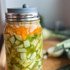 a mason jar filled with pickles and carrots