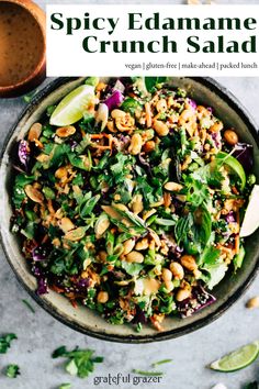 a bowl full of spinach salad with limes and cilantro on the side