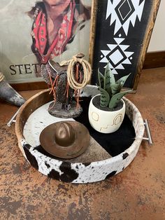 there is a cowboy hat and other items in the bowl on the table next to it