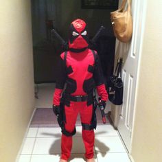 a person in a deadpool costume standing in a hallway