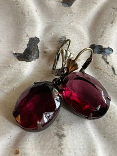 Vintage Translucent Garnet Earrings. These perfectly rosy red vintage jewels are translucent to bring out the best sparkle. These beautiful gems hang from fancy lever back ear wires. Ear wires are new and nickel free. The rhinestones are vintage. If you prefer a different ear wire than the one pictured, please state your preference in the message box at checkout. Stone size 18mm x 13mm Oval Total length approx. 1 3/8 inch Your purchase will arrive safely packaged ready for gift giving or a treat for yourself! All purchases will be sent USPS Ground Advantage with tracking and delivery confirmation. Thank you for visiting!  Return to our shop here http://www.etsy.com/shop/crowandcompany for more beautiful jewelry! Star Garnet, January Birthstone, Garnet Earrings, Holiday Earring, Birthstone Gifts, Red Earrings, Message Box, Red Vintage, Vintage Jewels