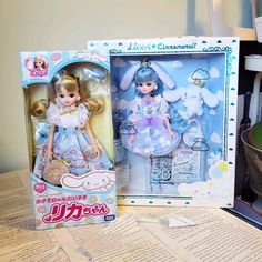 the doll is in its box on the table next to it's opened package