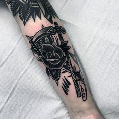 a black and white tattoo on the arm of a person with an owl holding a rose