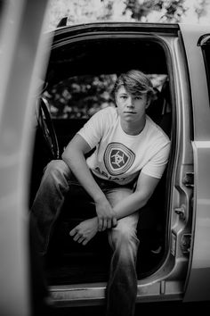 a young man sitting in the back of a truck