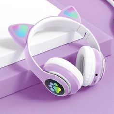 a pair of cat ears headphones sitting on top of a purple surface next to a computer keyboard