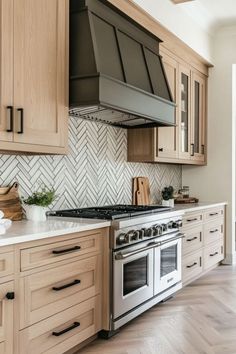 a kitchen with wooden cabinets and stainless steel stove top oven, white marble countertops and herringbone backsplash