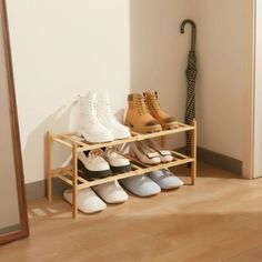 several pairs of shoes are lined up on a wooden shelf in front of a mirror