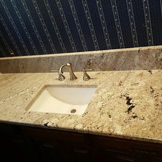 a bathroom sink sitting under a mirror next to a counter top with a faucet