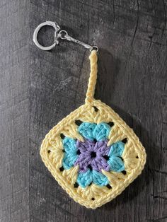 a crocheted keychain hanging on a wooden surface