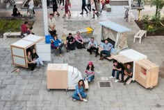 a group of people sitting around portable toilets