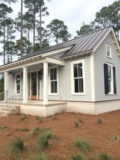 a small gray house sitting on top of a hill