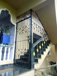 a stair case next to a set of stairs in a building with wrought iron railings