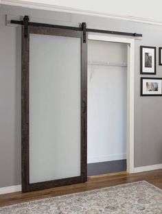 an open sliding door in a living room with pictures on the wall and carpeted floor