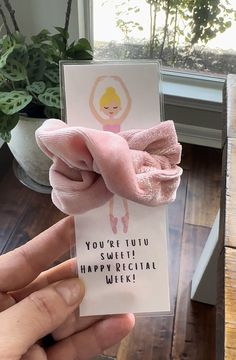 someone is holding up a card with a pink bow on it