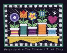 a quilted wall hanging with flowers in vases and ribbons on the bottom, saying friends are the threads that bind