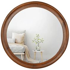 a round mirror reflecting a room with a chair and vase on the floor next to it