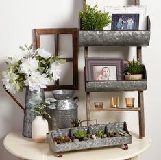 a shelf with flowers and pictures on it