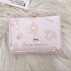 a pink wallet with hello kitty characters on it