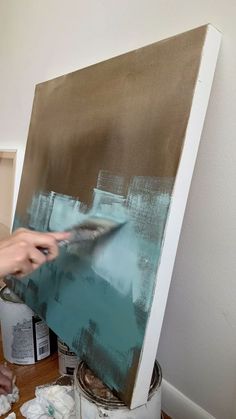 a person is painting on an easel in a room