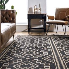 a black and white rug in a living room with two brown leather chairs next to a coffee table