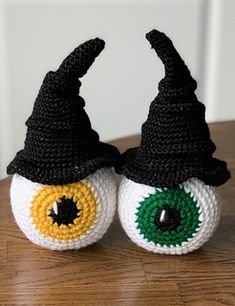 two crocheted witches hats sitting on top of a wooden table