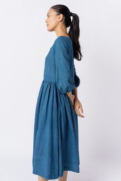 Effortless elegance in this indigo midi dress with waist gathers, a relaxed fit, and a gentle scoop neckline. Crafted from soft textured cotton, it offers year-round comfort and versatility for your everyday style. Puff Sleeve Dress With Gathered Sleeves For Gatherings, Spring Midi Dress For Gatherings, Knee-length Cotton Midi Dress With Gathered Waist, Cotton Peasant Dress With Gathered Sleeves, Midi Dress With Gathered Neckline For Gatherings, Mid-length Dress With Gathered Neckline, Cotton Maxi Dress With Gathered Sleeves, Cotton Midi Dress With Gathered Skirt For Daywear, Cotton Ruched Empire Waist Dress