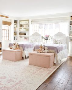 two twin beds in a bedroom with pink and white decor on either side of them