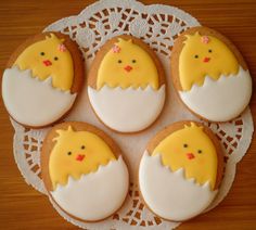 four decorated cookies sitting on top of a doily