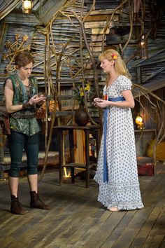 two women standing on a wooden floor next to each other