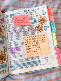 an open bible with sticky notes attached to the pages and colorful stickers on it